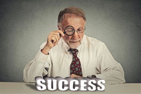 Business Man Looking Through Magnifying Glass At Success Sign Stock