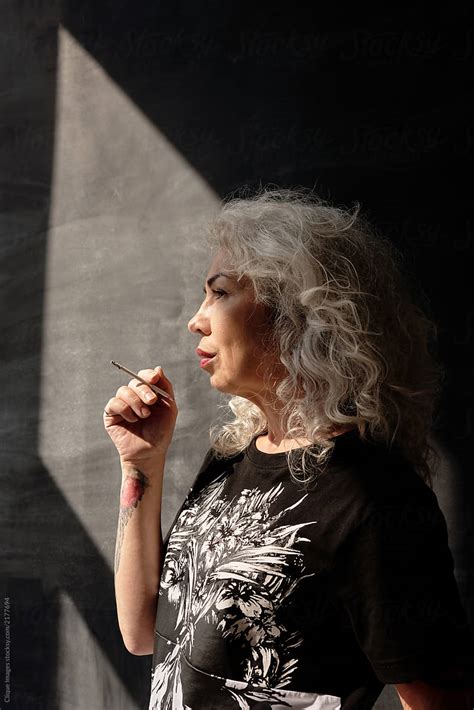 cool senior woman smoking by stocksy contributor clique images stocksy