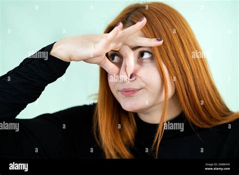 Funny Pretty Redhead Girl Showing Bad Smell Sign With Her Fingers Stock