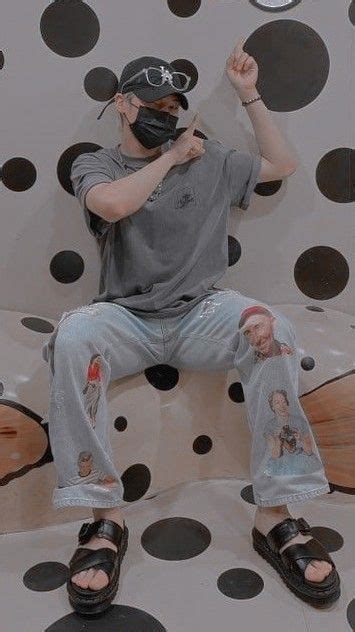 A Man Sitting On Top Of A Polka Dot Covered Couch With His Hands In The Air