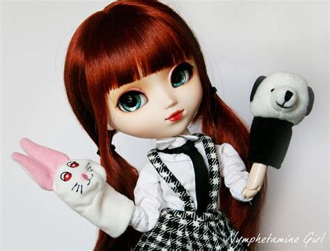 A Doll With Long Red Hair Holding A Black And White Stuffed Animal In
