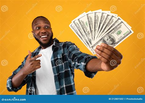 Happy Black Man Holding Money Cash Standing Over Yellow Background