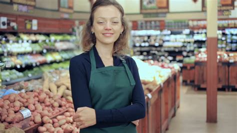 Portrait Of A Grocery Store Clerk In Front Of A Vegetable Section Of