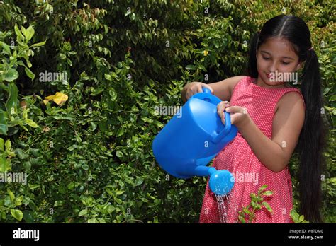 Girl Watering Plants In A Garden Stock Photo Alamy