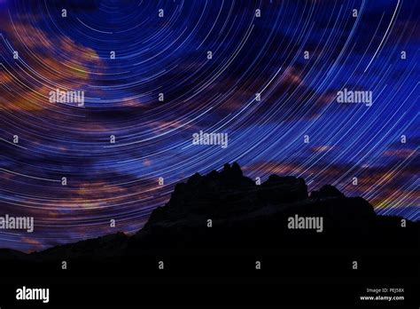 Long Exposure Image Showing Night Sky Star Trails Over Mountains Stock