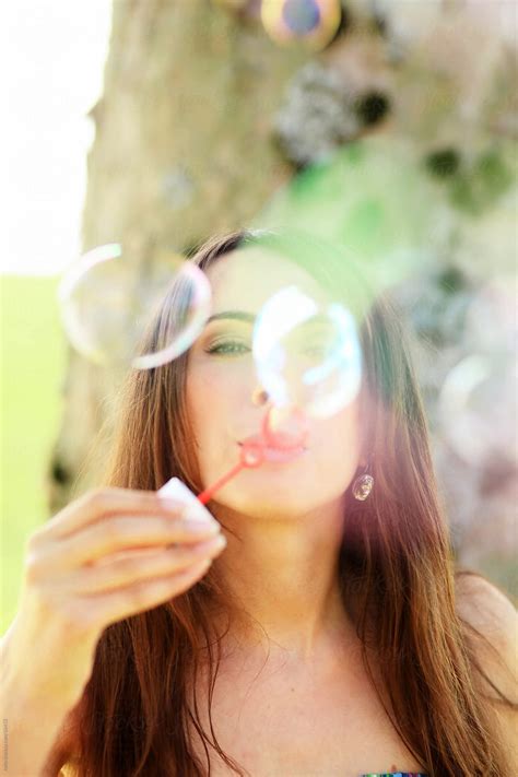 Girl Blowing Bubbles Outdoors Del Colaborador De Stocksy Rolfo
