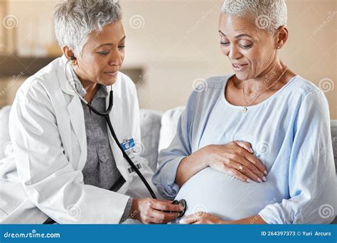 Pregnant Consulting And Doctor With Woman On A Sofa For Medical Checkup Health And Exam During