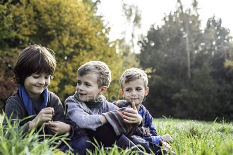 Three Boys Sitting Together In Field In Autumn — Fun Field Landscape