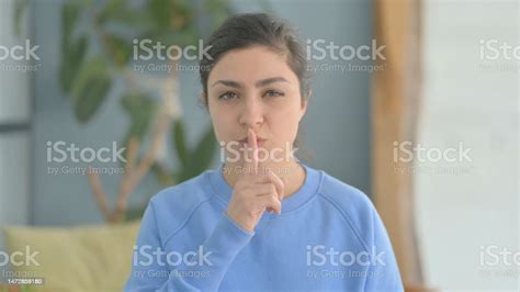 Indian Woman With Finger On Lips Asking For Silence Stock Photo