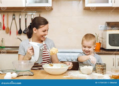 El Muchacho Del Niño Ayuda A La Madre A Cocinar La Galleta Del Jengibre