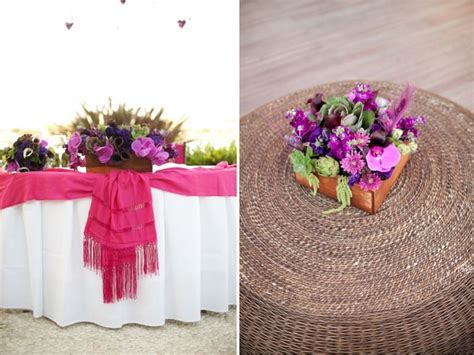 The Table Is Decorated With Purple Flowers And Pink Sashers On It