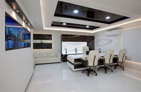 An Office With White Chairs And Black Tables In The Center Is Lit By