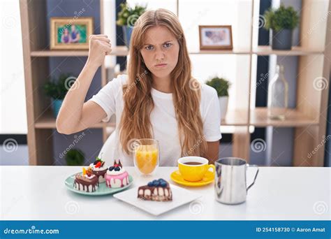 Young Caucasian Woman Eating Pastries T For Breakfast Angry And Mad