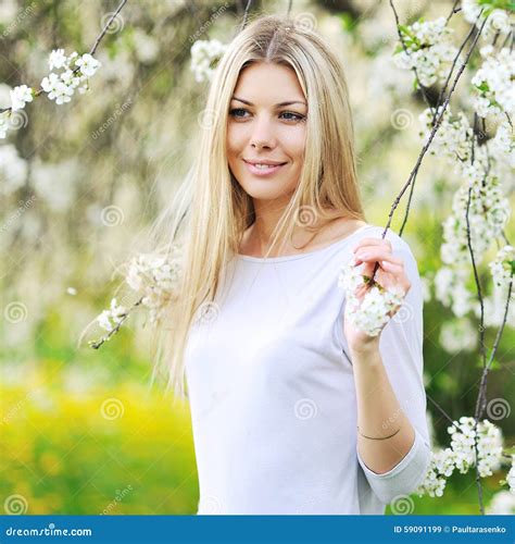 Beautiful Blonde Woman In A Blooming Garden In Spring Stock Image