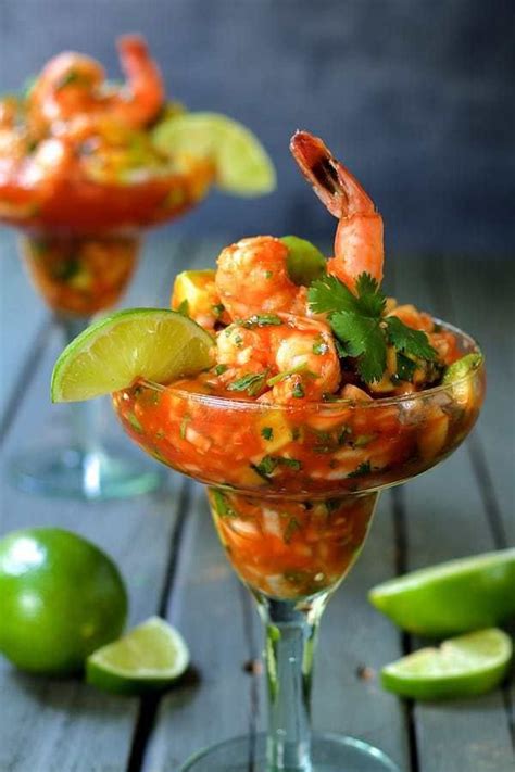 The Mexican Shrimp Cocktail Is Garnished With Limes And Cilantro Sauce