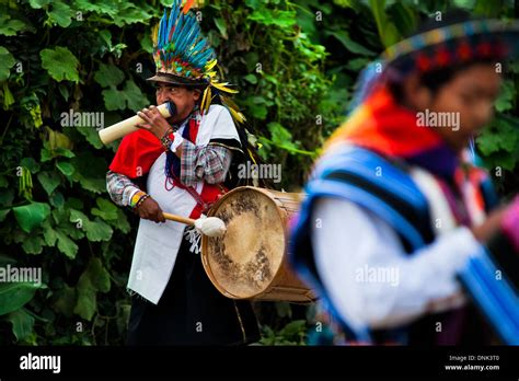 a native from the kamentsá tribe wearing a colorful headgear plays drum during the carnival in