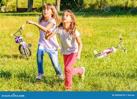 Dos Niñas Felices Que Juegan En El Parque Foto De Archivo Imagen De