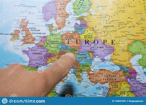 Finger Pointing To A Colorful Country Map Of Europe Deciding Which