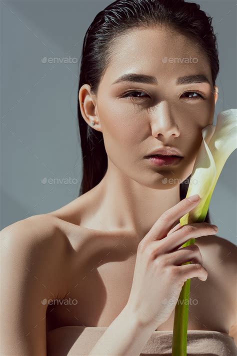 Attractive Naked Asian Woman With Calla Flower Isolated On Grey Stock