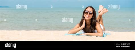 Young Happy Beautiful Asian Woman Lying On Stomach Taking A Sunbath