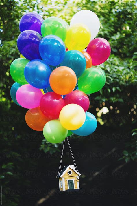Bunch Of Colourful Helium Balloons Liftng A Yellow Wood House By