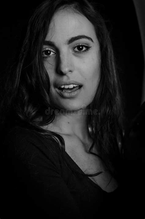 black and white portrait of a beautiful italian girl with long hair who looks surprised and