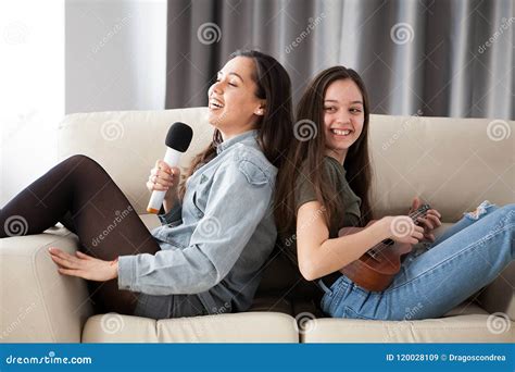 Happy Laughing Sisters On The Couch In The Living Room Stock Image