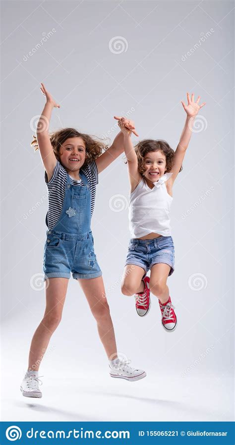 Two Exuberant Hyperactive Young Girls Jumping Stock Image Image Of