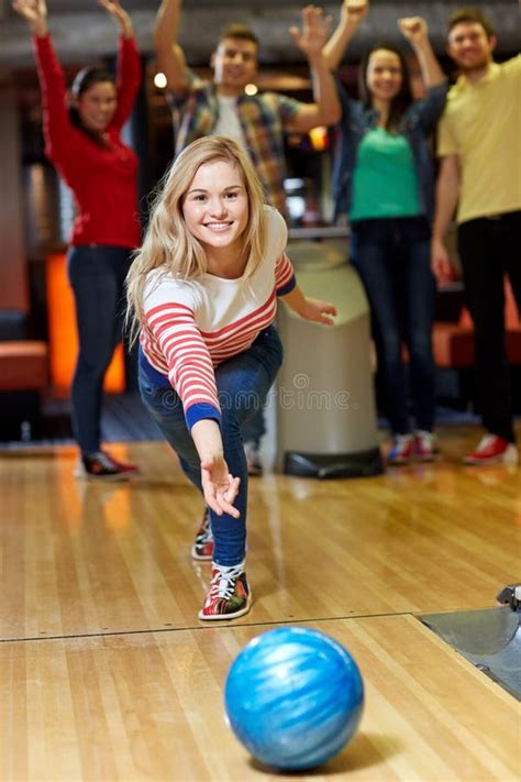 Happy Young Woman Throwing Ball In Bowling Club Stock Photo Image Of