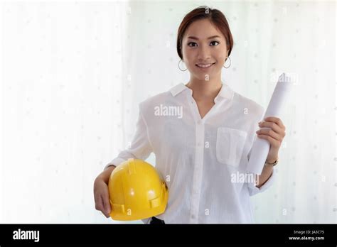 Asian Women Engineering Holding Blueprints Hard Hat For Working At