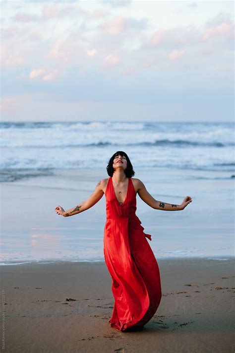 Portrait Of Woman With Red Dress And Tattoos On The Beach By Stocksy Contributor Thais Ramos