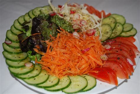 Assiette de crudités composée de carottes tomates chou blanc salade