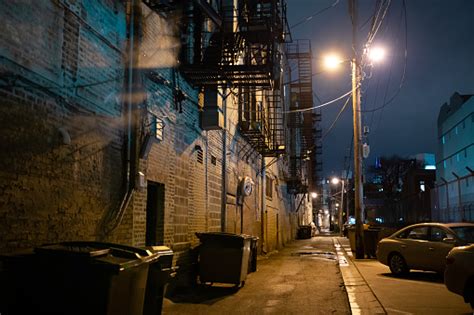 Dark And Eerie Downtown Urban City Alley At Night Stock Photo