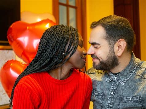premium photo portrait of an interracial couple kissing in a romantic gesture while enjoying