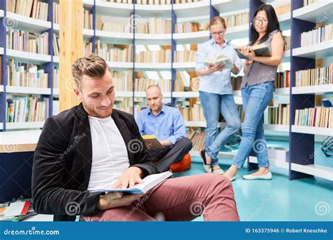 Group Of Young People While Reading Book In Library Stock Photo Image