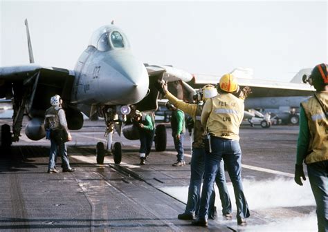 A Catapult Crewman Guides A Fighter Squadron 143 Vf 143 F 14b Tomcat