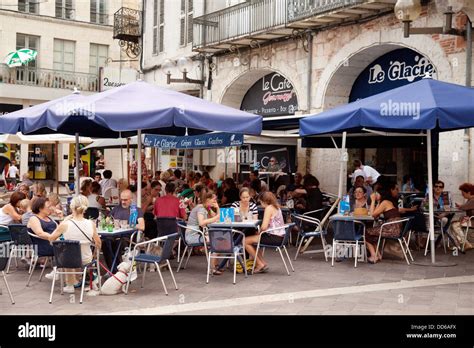 People Sitting Drinking And Eating Outside At A Street Cafe Stock Photo