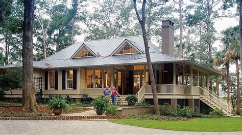 Two People Are Standing In Front Of A Large House With Porches And