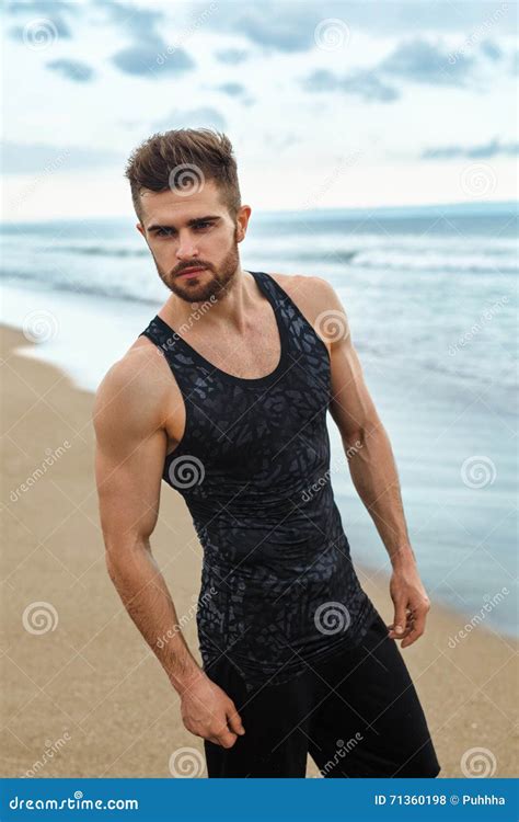 Uomo Bello Con L Ente Muscolare Di Misura In Abiti Sportivi Sulla Spiaggia Fotografia Stock
