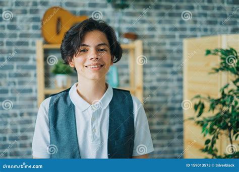 Portrait Of Teenage Boy Smiling Looking At Camera Standing Alone At