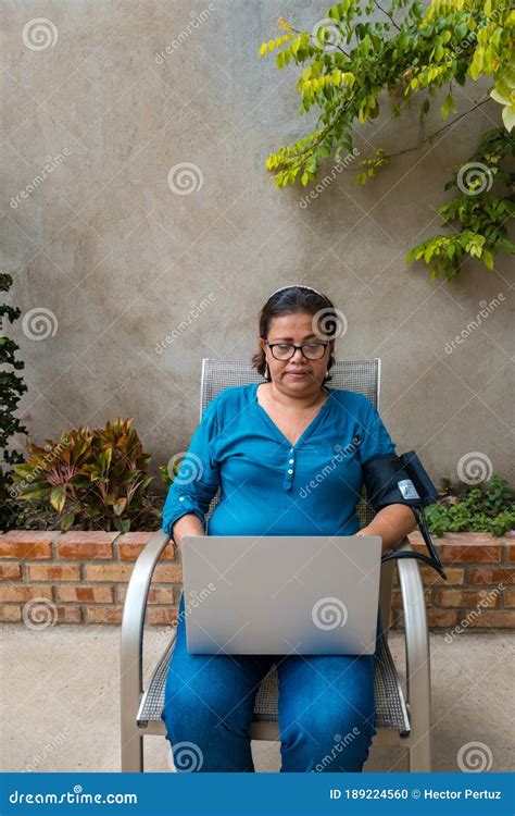 An Older Hispanic Woman Checking Her Blood Pressure And Pulse At Home