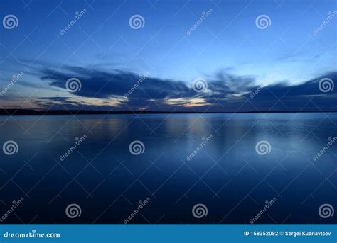 Blue Sky In The Twilight Glow From Behind Clouds Over The Azure Calm