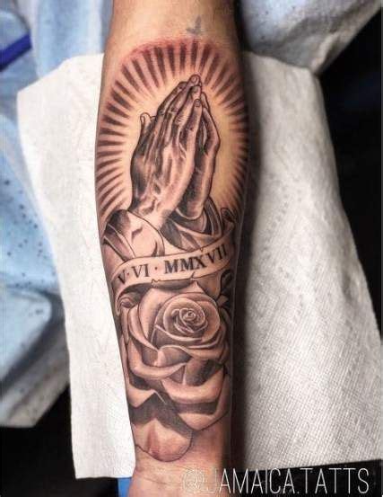 The praying hands are very realistic and the rosary they hold that represents catechism. Forearm prayer hands tattoo with roses on Stylevore
