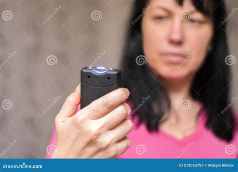 A Woman Will Use A Stun Gun With A Powerful Electric Discharge The Girl Holds A Personal Taser