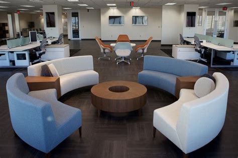 An Office With Several Couches And Chairs Around A Round Table In The