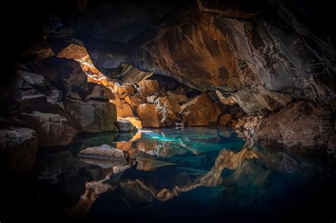 Iceland Cave Surrouned With Blue Body Of Water 5k Hd