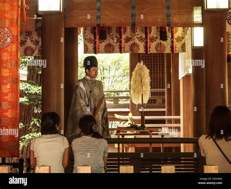 A Shinto Priest In Traditional Robes Takes Part In A Ritual Ceremony