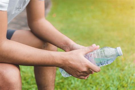 Young Asian Man Runner Relaxing Holding Drinking Water Bottle And
