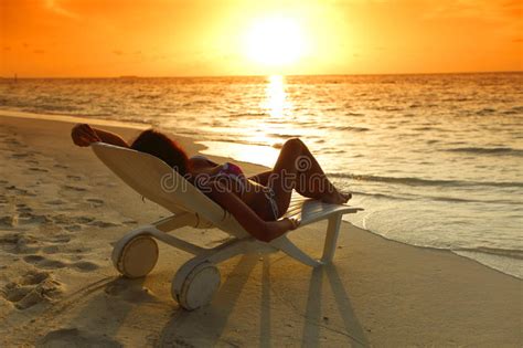 Mulher Na Chaise Sala De Estar Que Relaxa Na Praia Foto De Stock Imagem De Relaxe Relaxamento