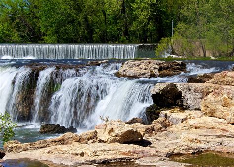 there is a waterfall that has water coming out of the rocks and into